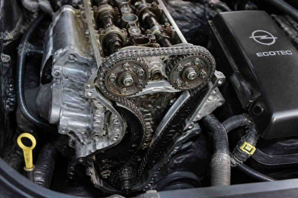 Odsłonięty układ rozrządu silnika Opel Ecotec z widocznymi wałkami i łańcuchem rozrządu